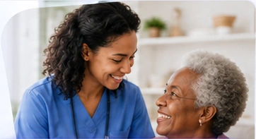 Home care nurse in blue scrubs talking with a senior woman